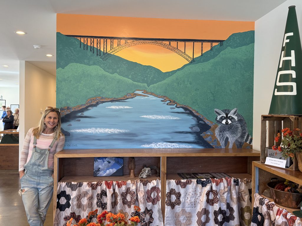 Mural by local Artist Kelly Lacava of New River Gorge Bridge with racoon and mountains 

